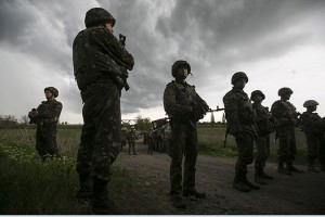 Ukrainian soldiers stand in front of pro-Russian civilians (not in picture) at a checkpoint near the town of Slaviansk