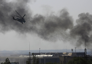 A Ukrainian helicopter Mi-24 gunship fires its cannons against rebels at the main terminal building of Donetsk international airport